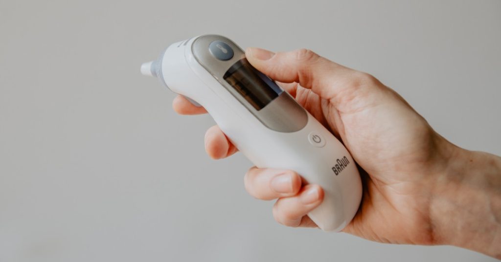 hand holding electronic thermometer