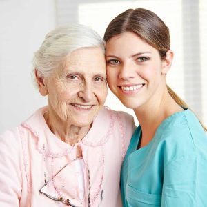 elderly woman and caretaker smiling