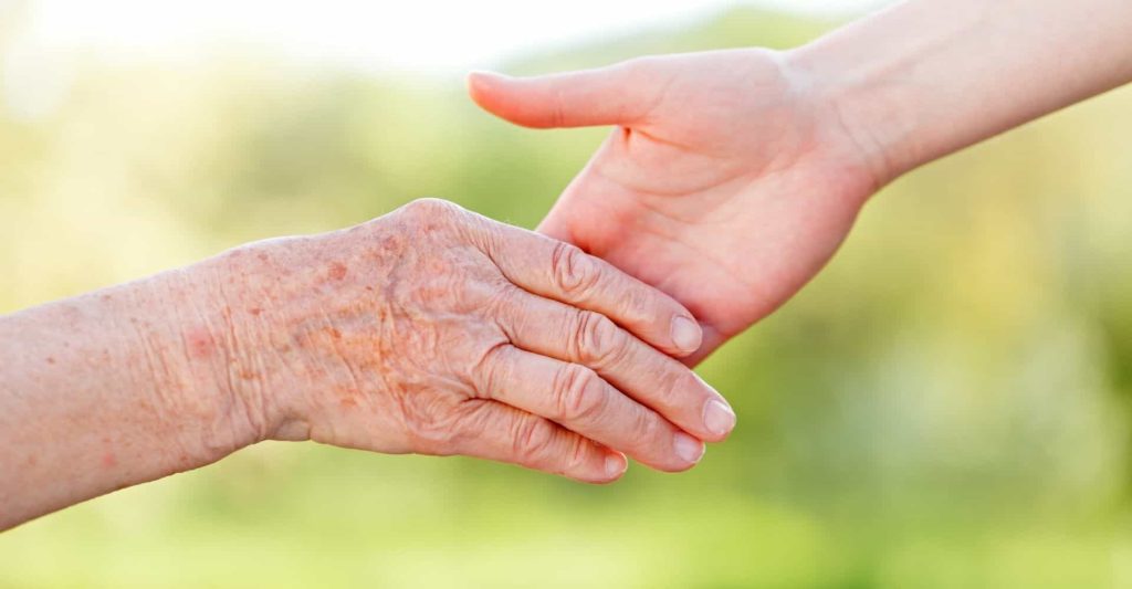 young and old holding hands