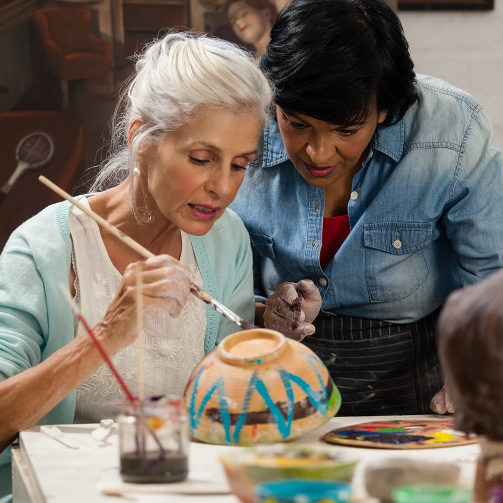 senior woman painting pottery