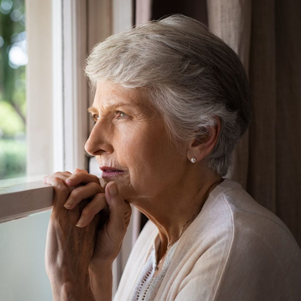img of an older woman looking out the window