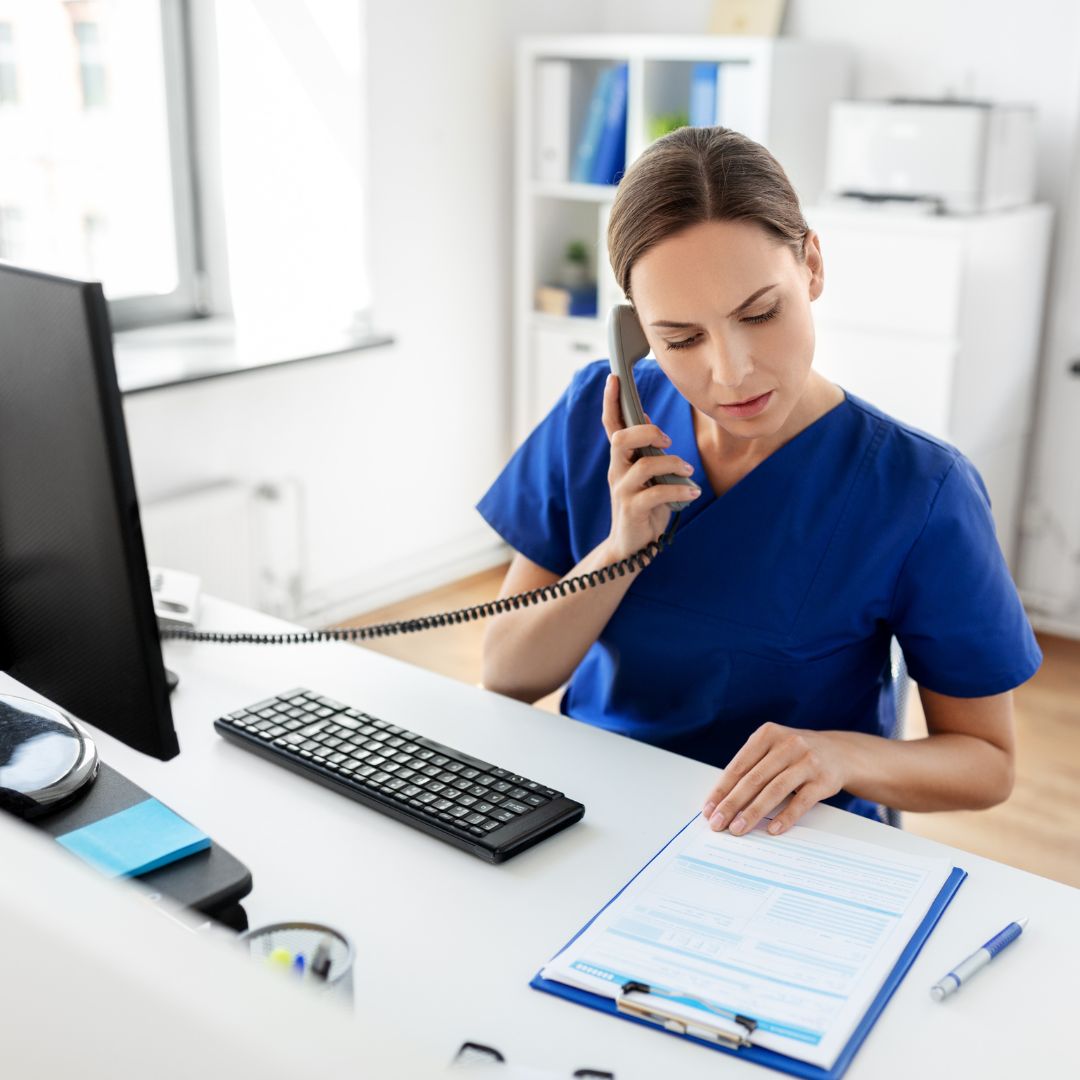 Nurse on phone referencing notes