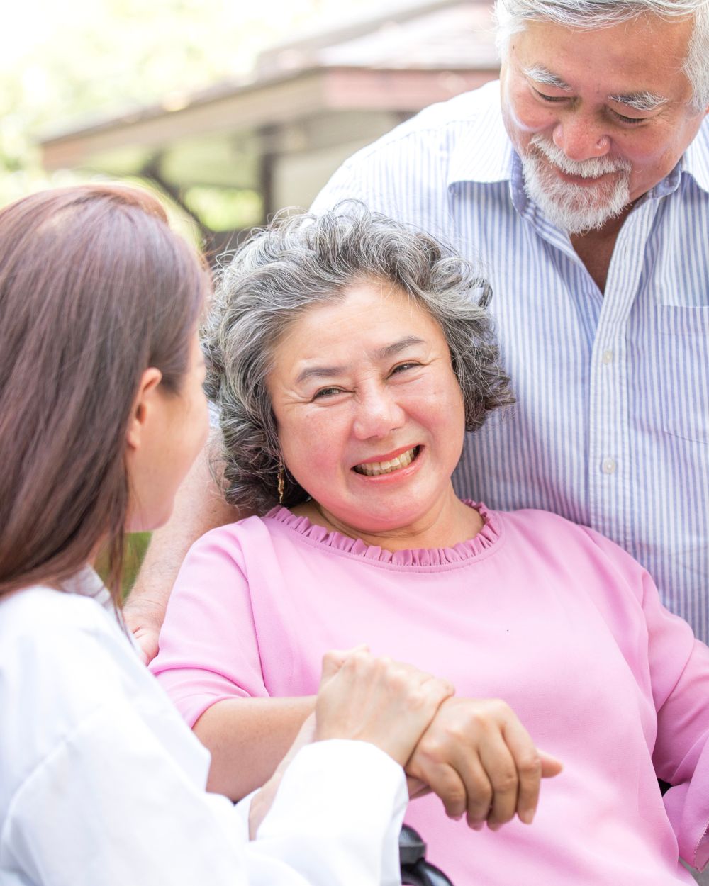 an elder couple outside with their caregiver